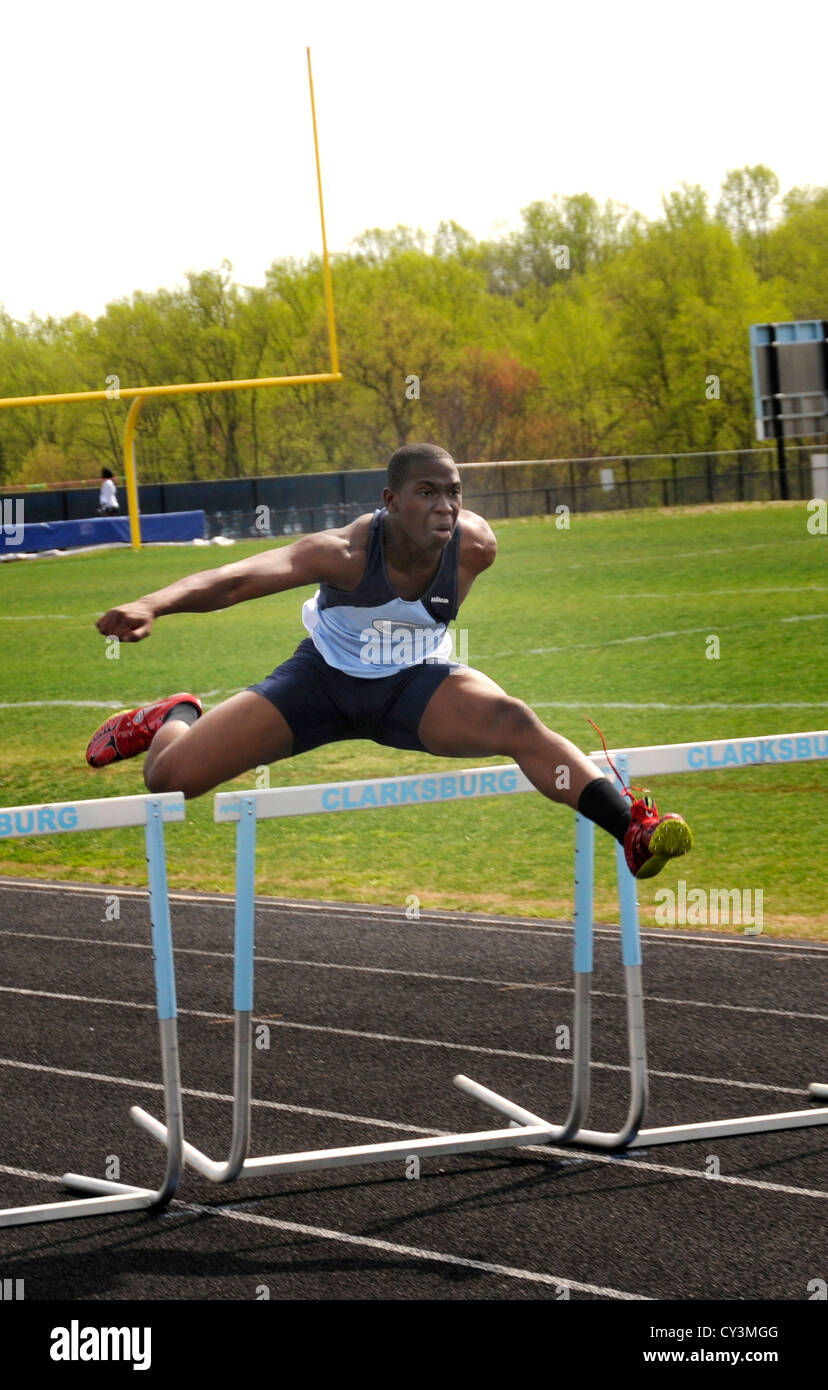 A teen jumping hurdles in a track & field event in Clarksburg, Maryland