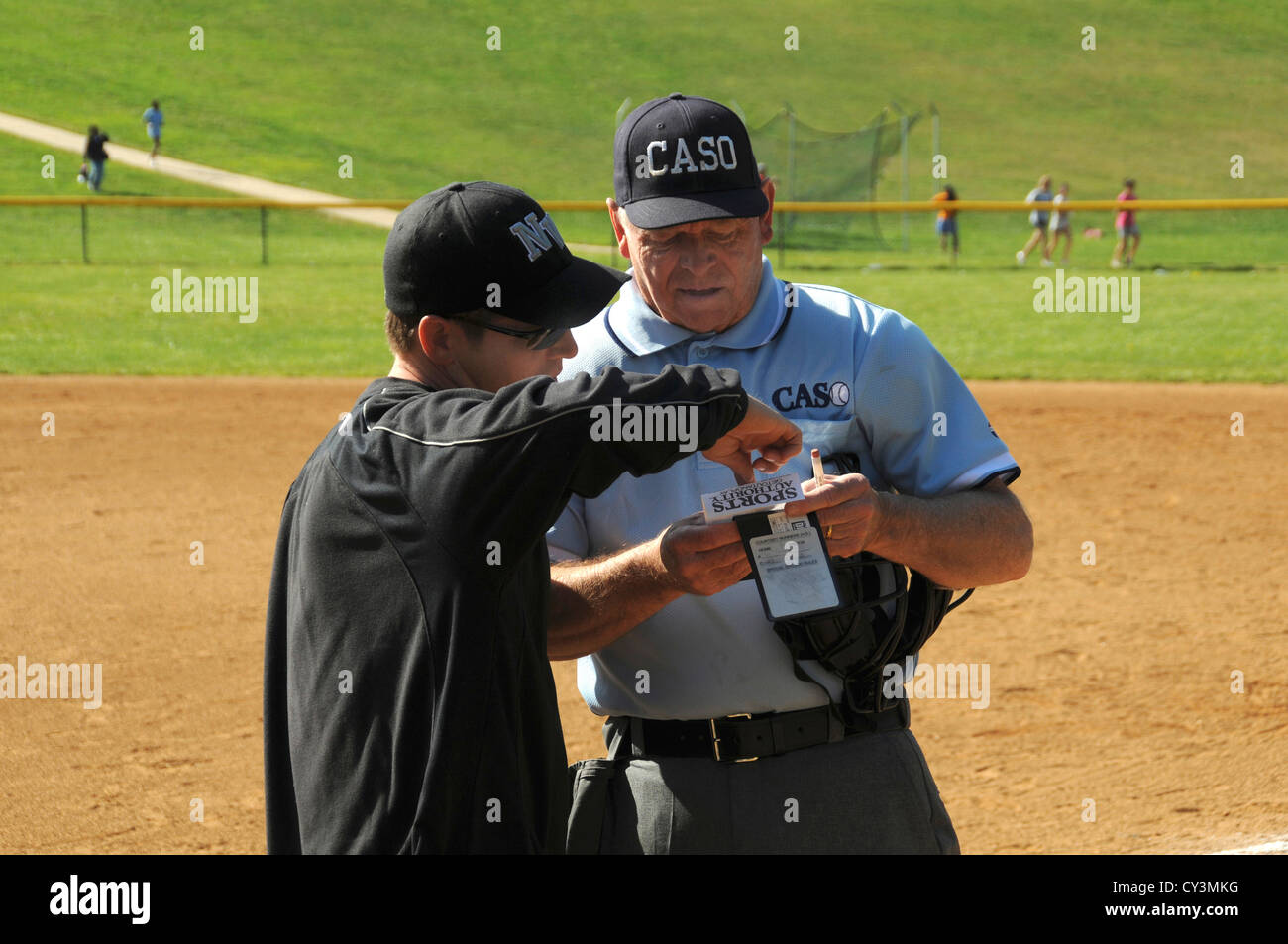 coach explains the lineup to the umpire in a high school softball game