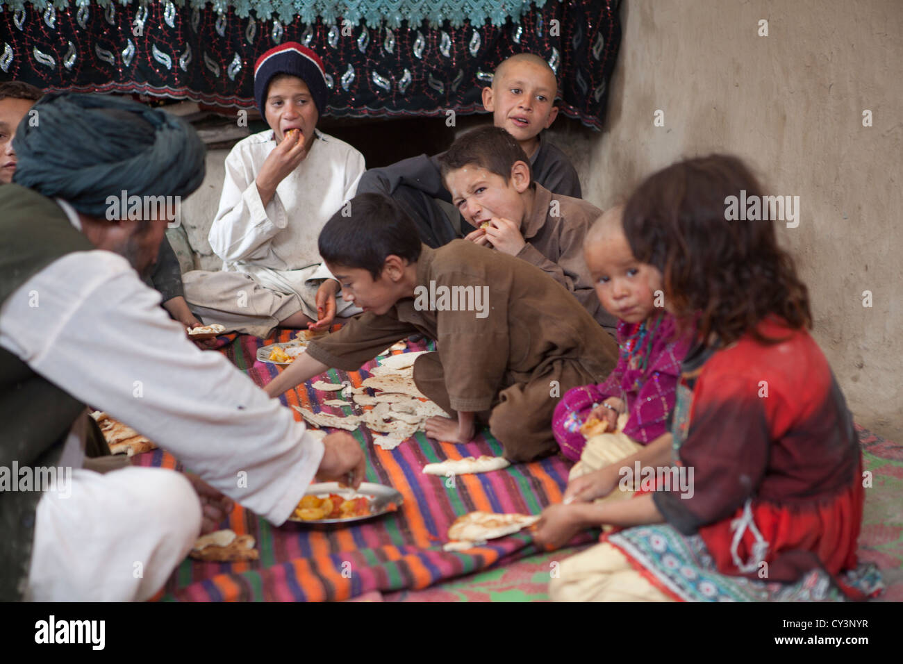 Afghan family having lunch in their mud house Stock Photo