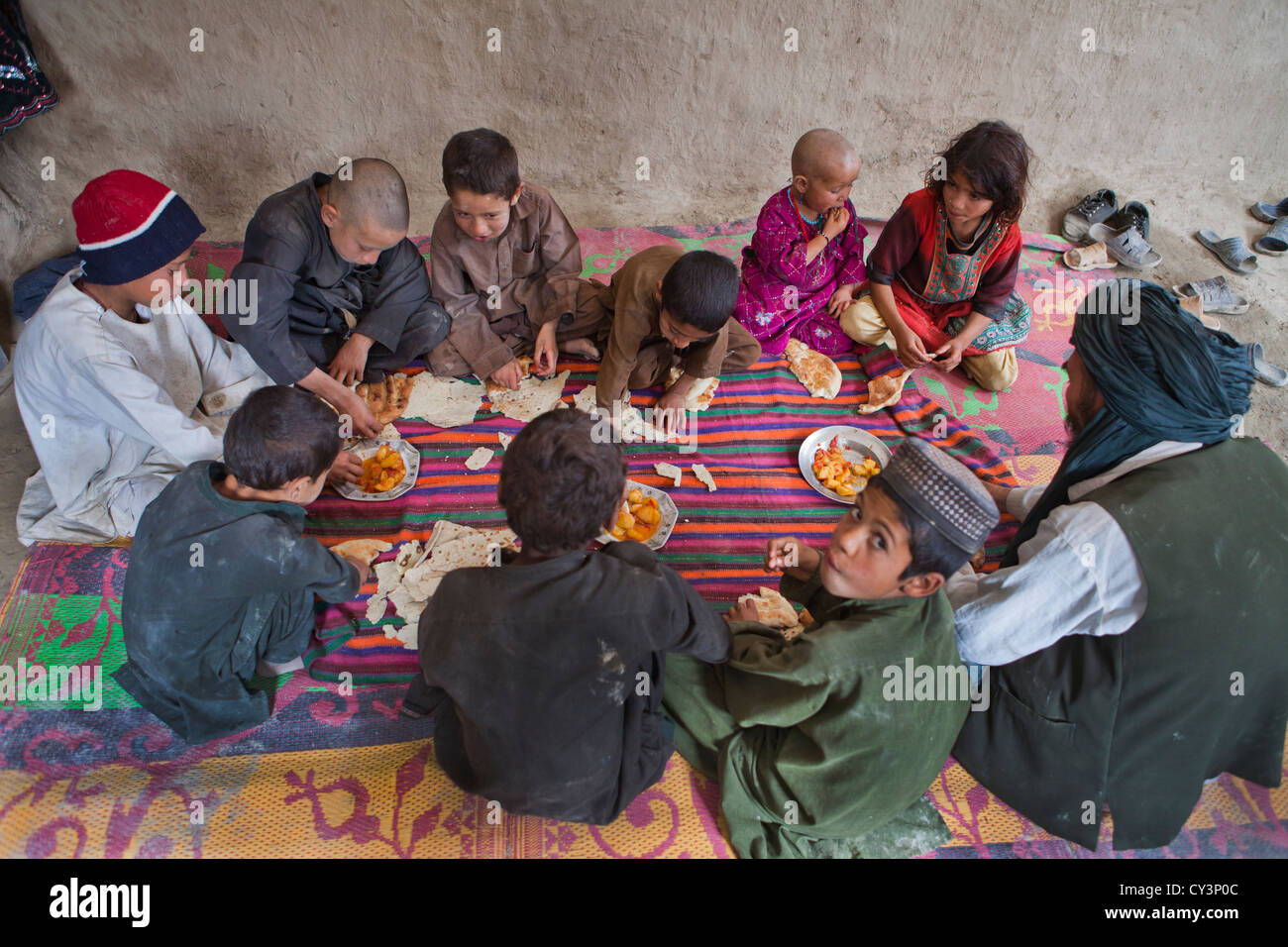 Afghan family having lunch in their mud house Stock Photo