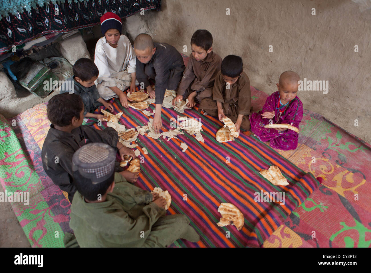 Afghan family having lunch in their mud house Stock Photo