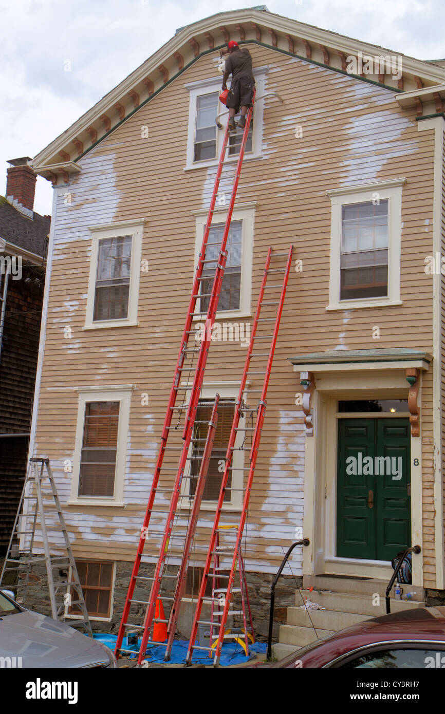 Rhode Island Newport,Barney Street,house painter,ladder,tall,high,Black man men male adult adults,dangerous,working work worker workers,employee staff Stock Photo