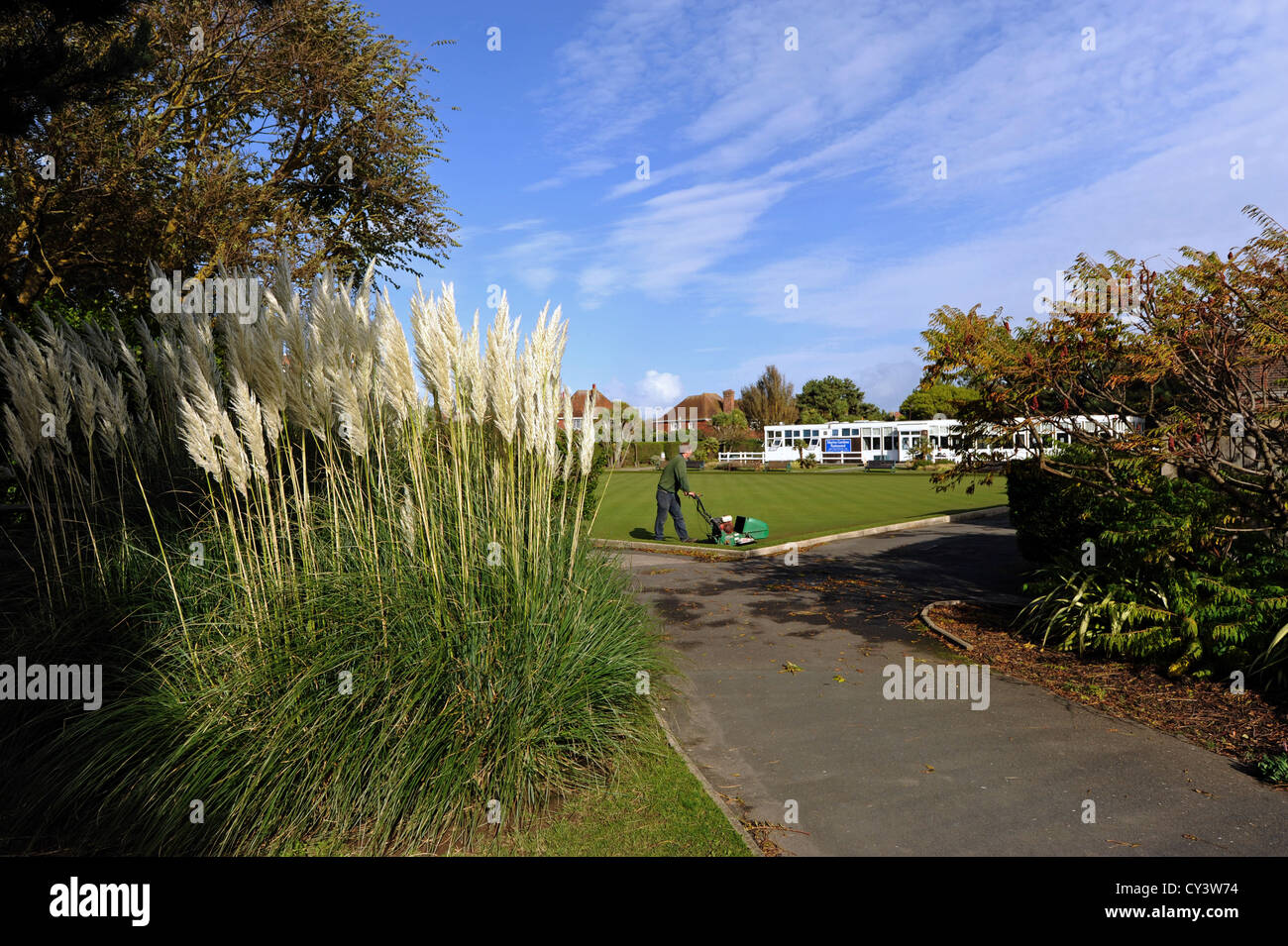 Gardener or groundsman mowing the grass at Marine Gardens and bowls club Worthing West Sussex UK Stock Photo