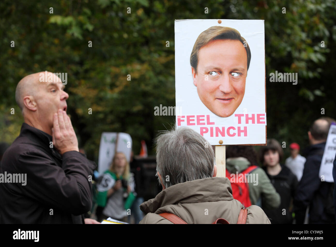 Poster placard caricaturing David Cameron reading 'Feel the Pinch' TUC anti austerity government cuts march rally, London, UK Stock Photo