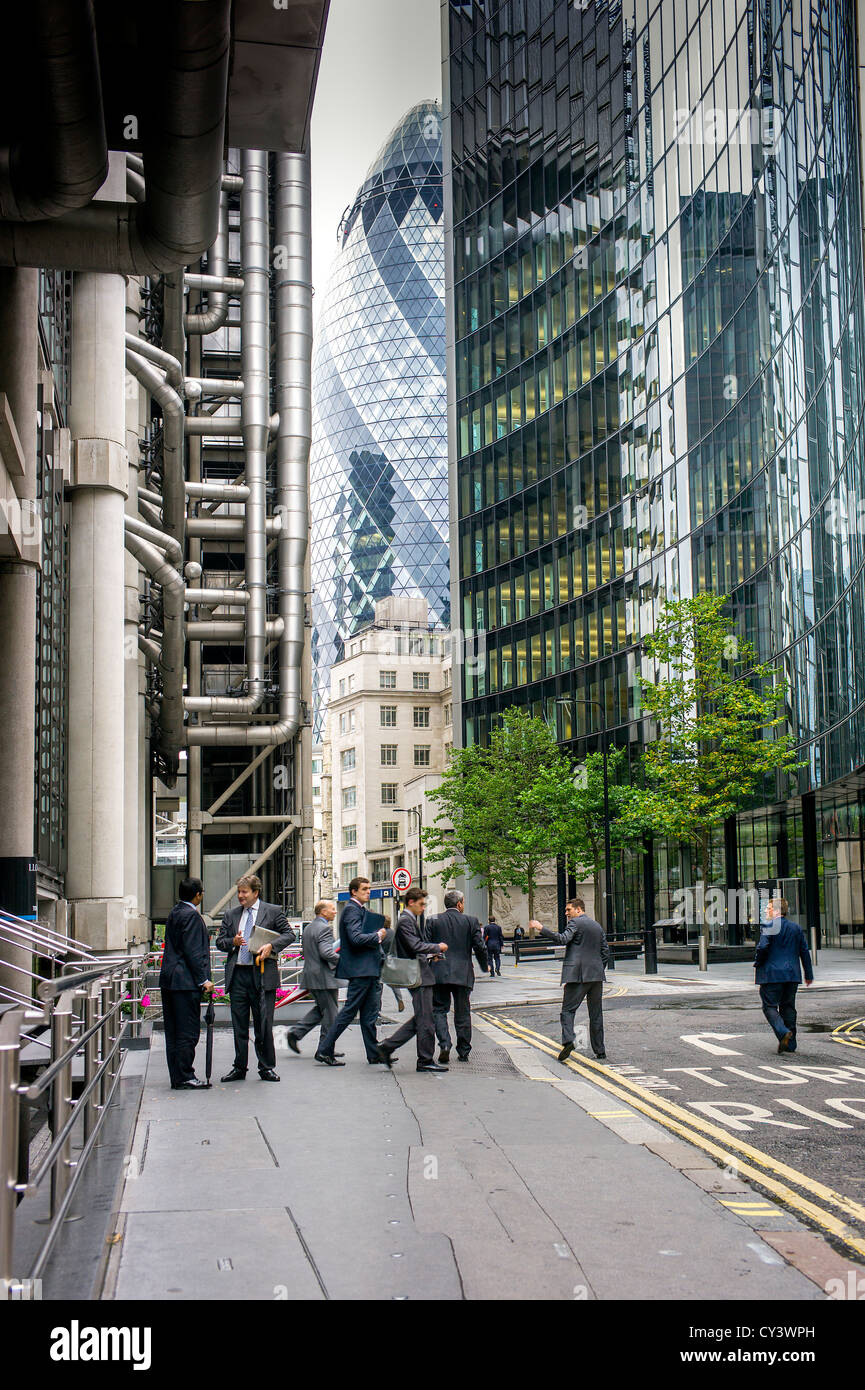 Adult male city workers leaving Lloyds building lime street with surrounding high office blocks, gherkin office in background Stock Photo