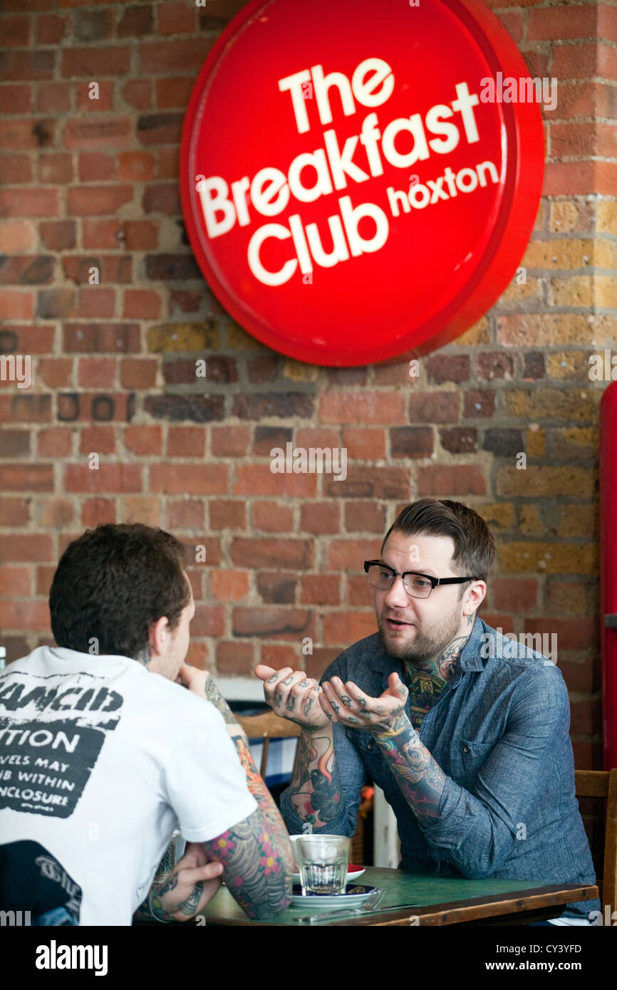 Two men sit and talk in the Breakfast club, a lounge and diner off Hoxton Square. Hackney, London UK Stock Photo