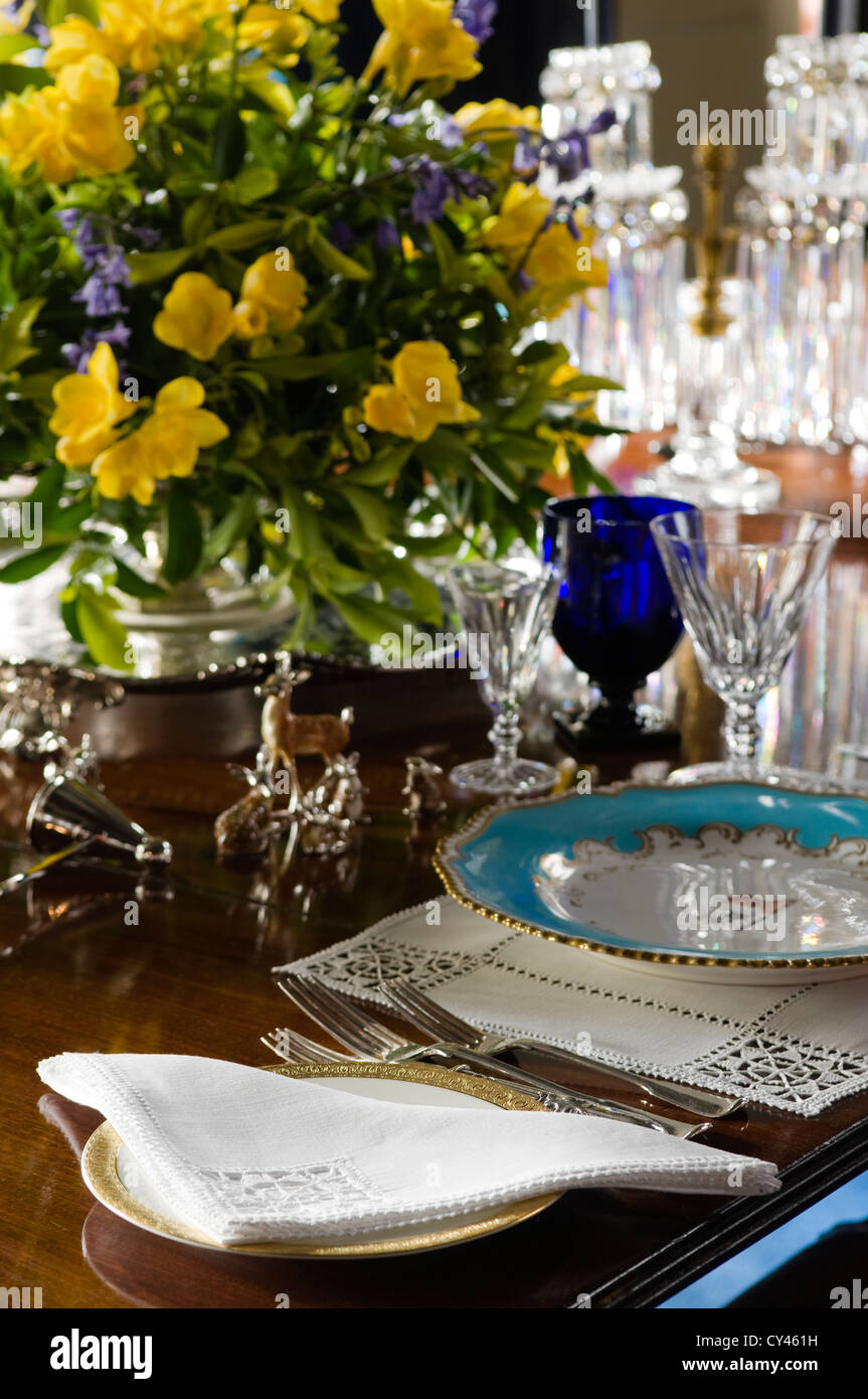 Detail of a place setting on a dining table with china plate and cotton napkin Stock Photo