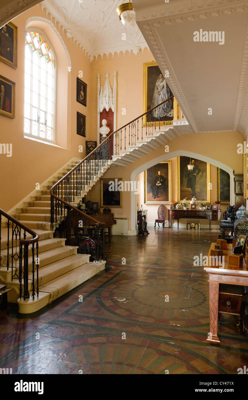 Staircase and entrance hall with original floor tiles and full length paintings Stock Photo