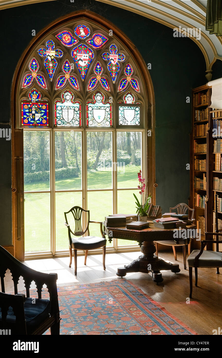 Large arched stained glass window in library with octagonal writing table Stock Photo