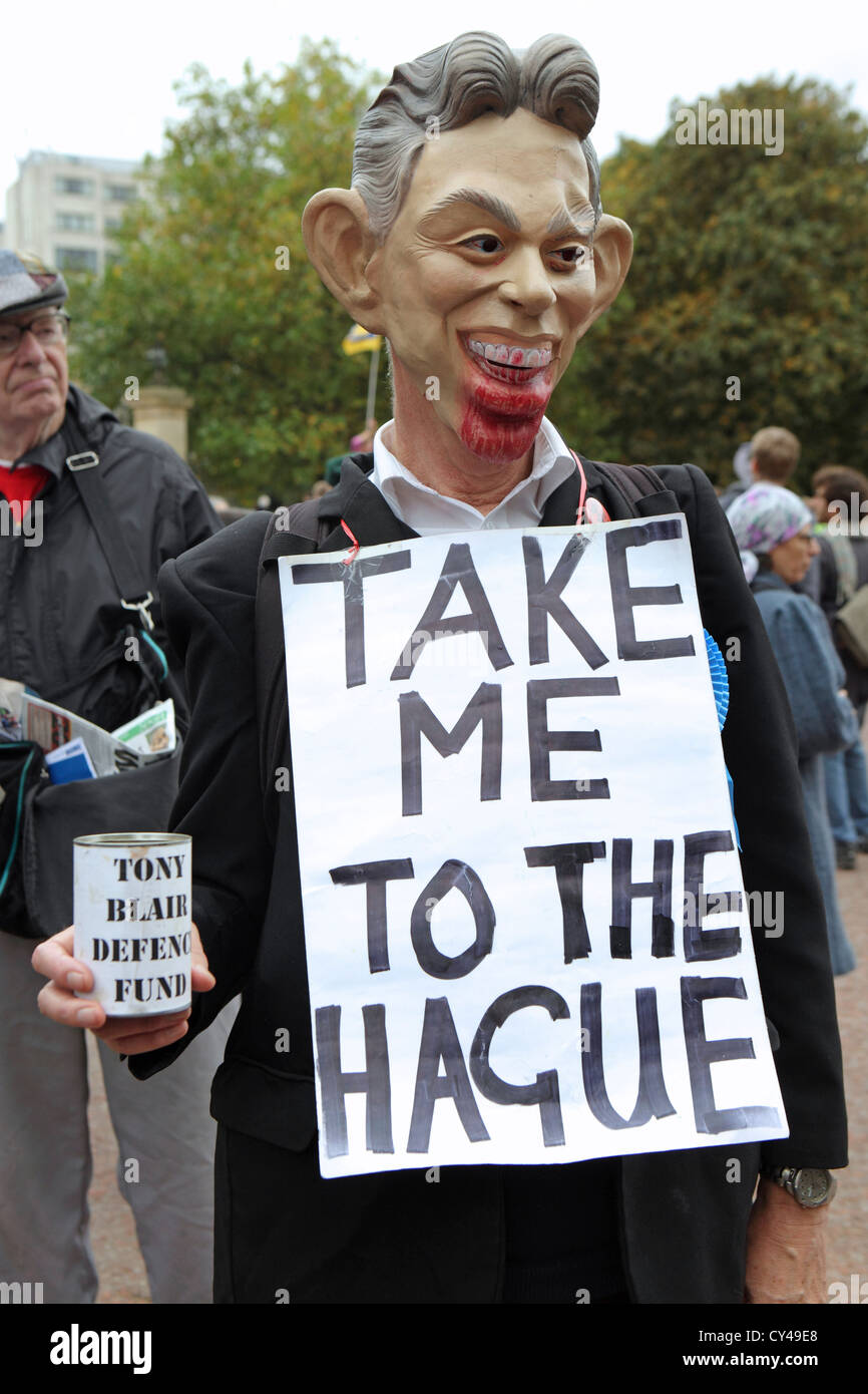 Protester wearing bloodied Tony Blair mask and wearing placard reading, 'Take Me to the Hague', London UK Stock Photo