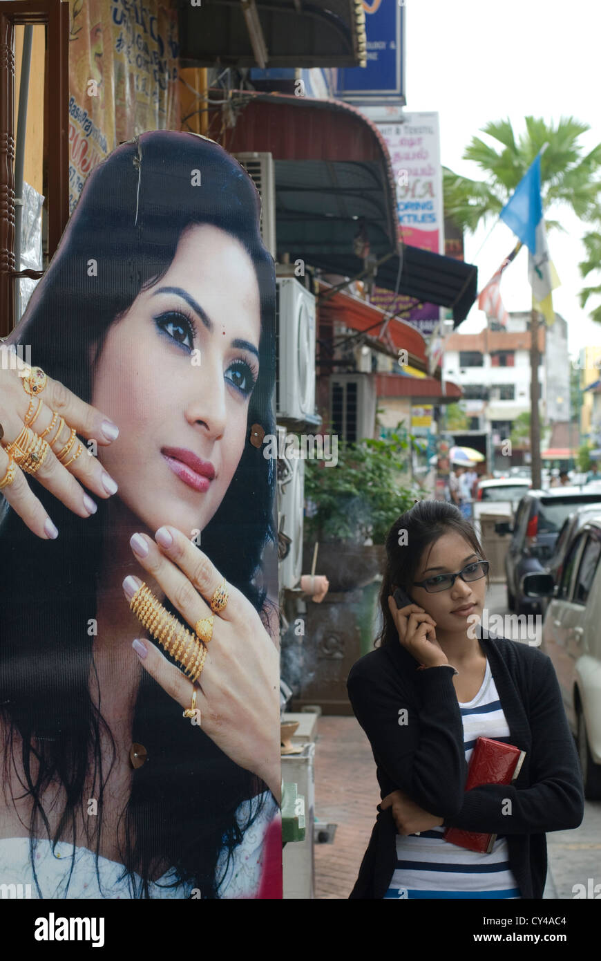 A woman uses her moblile phone outside a jewellers in Little India in Georgetown, on Malaysia's Penang Island Stock Photo