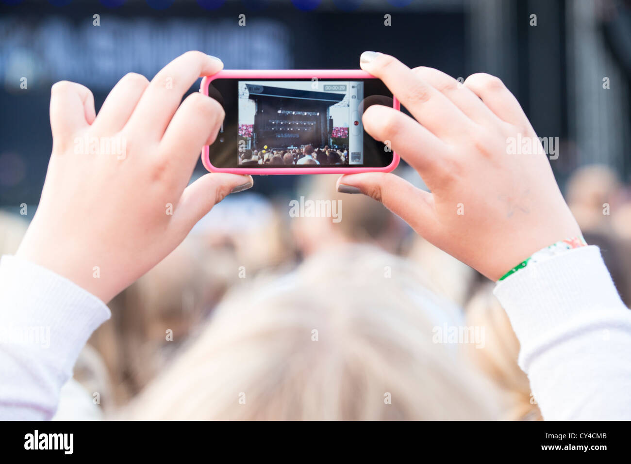 Teenager recording a performance of The Rasmus on her mobile phone on Helsinki Day in Kaisaniemi Park, Helsinki Stock Photo