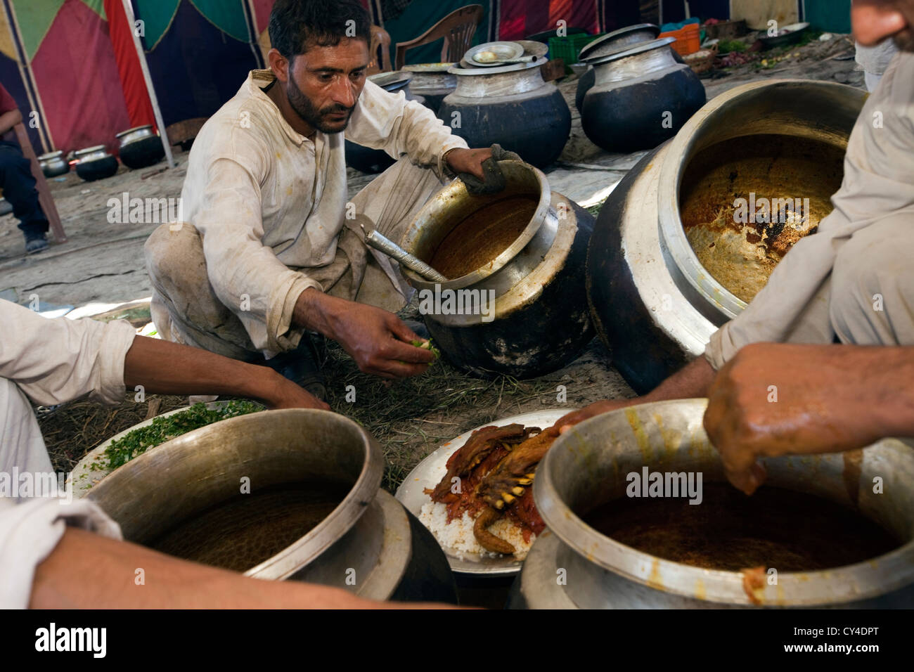 Wazas, traditional Kashmiri cooks, serve Wazwan onto a Trami (plate) at