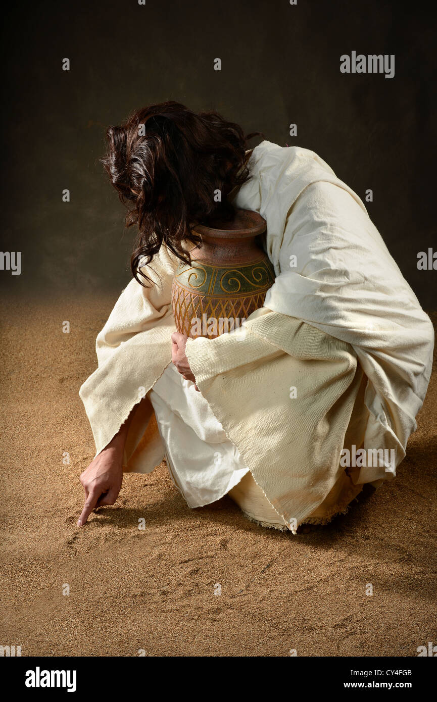 Jesus writing with finger in the sand Stock Photo