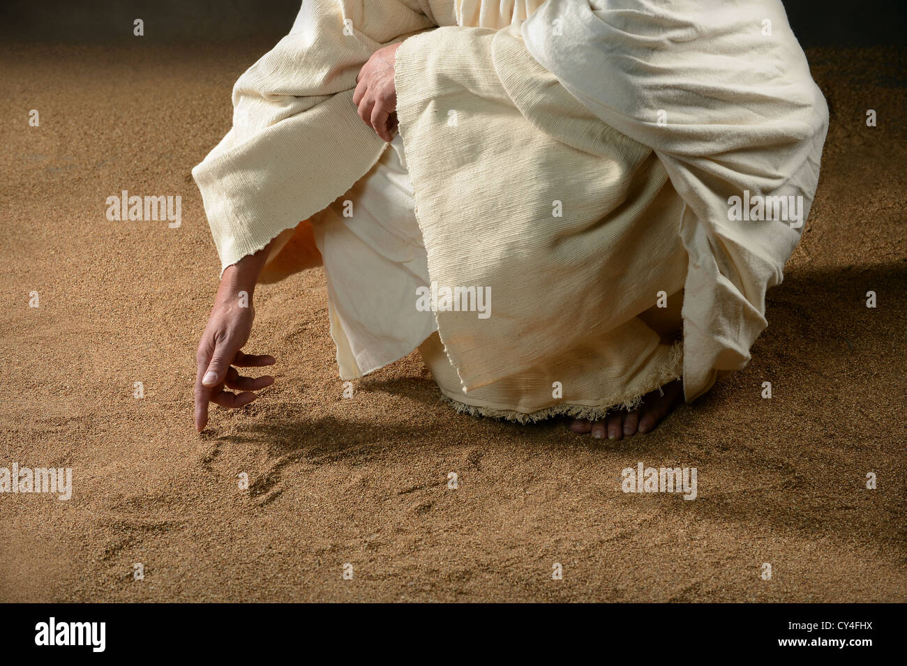 Jesus writing in the sand with finger Stock Photo