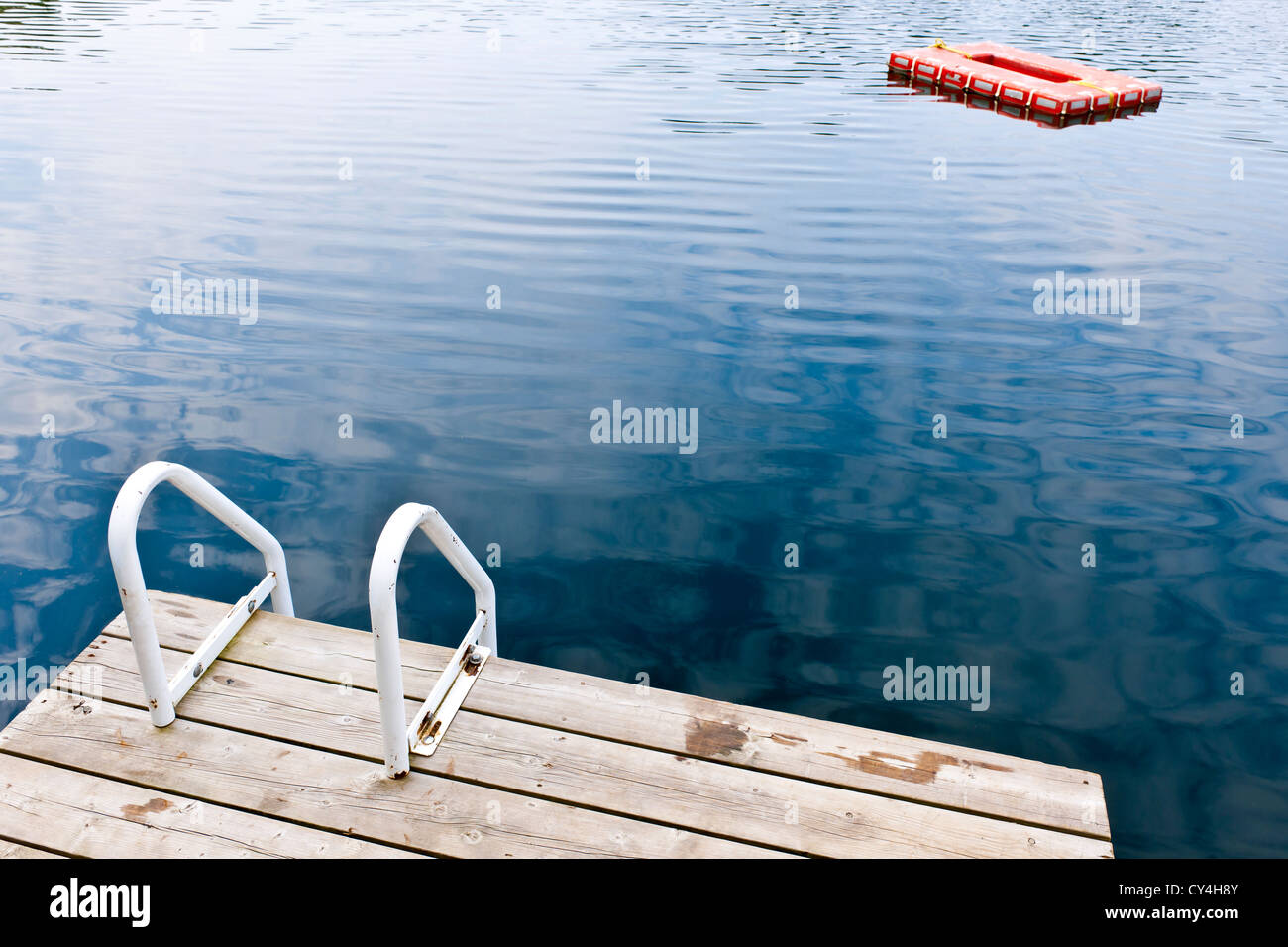 Dock and ladder on calm summer lake with diving platform in Ontario
