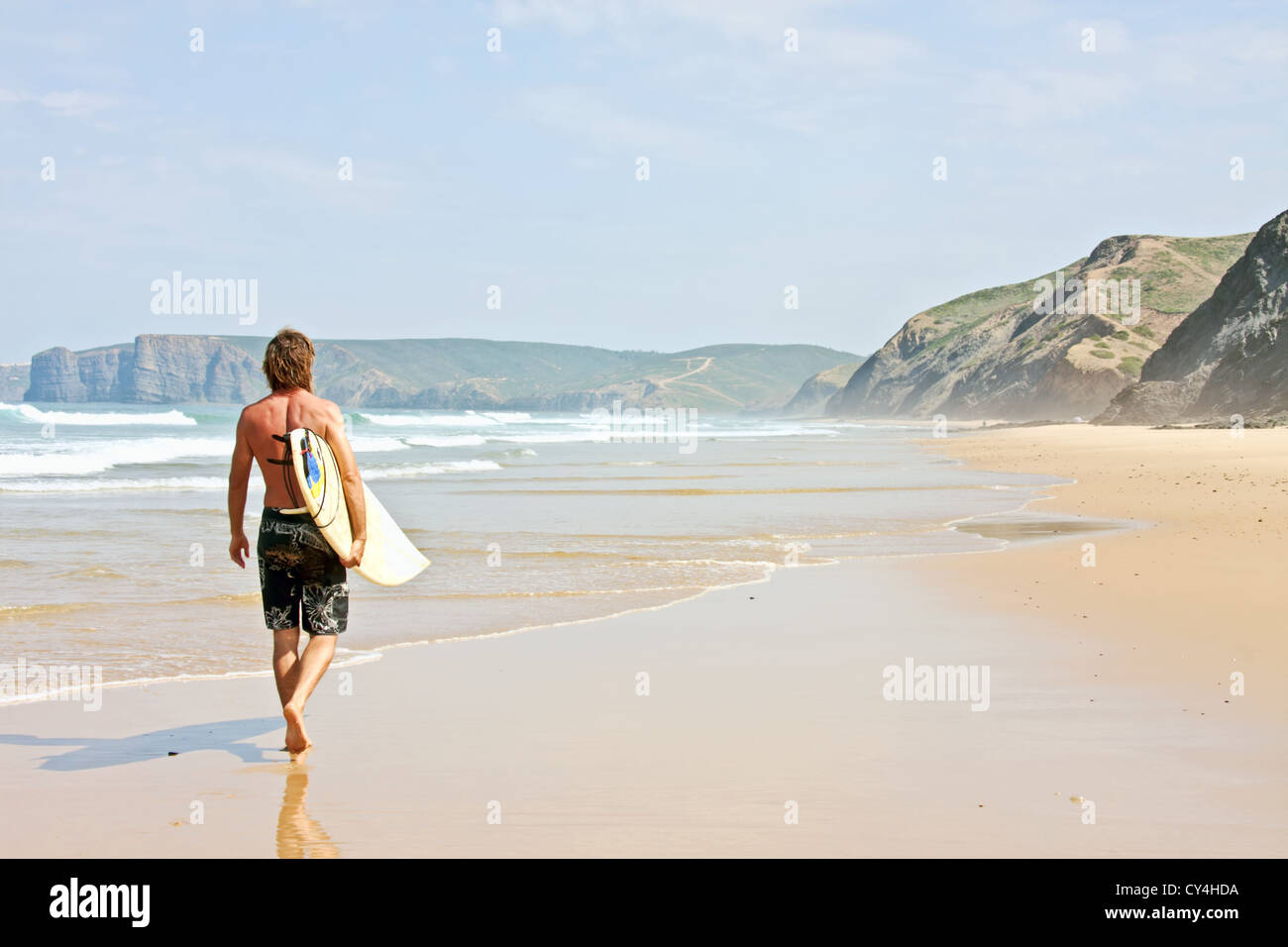 Surfer walking with his surfboard at the beach Stock Photo - Alamy