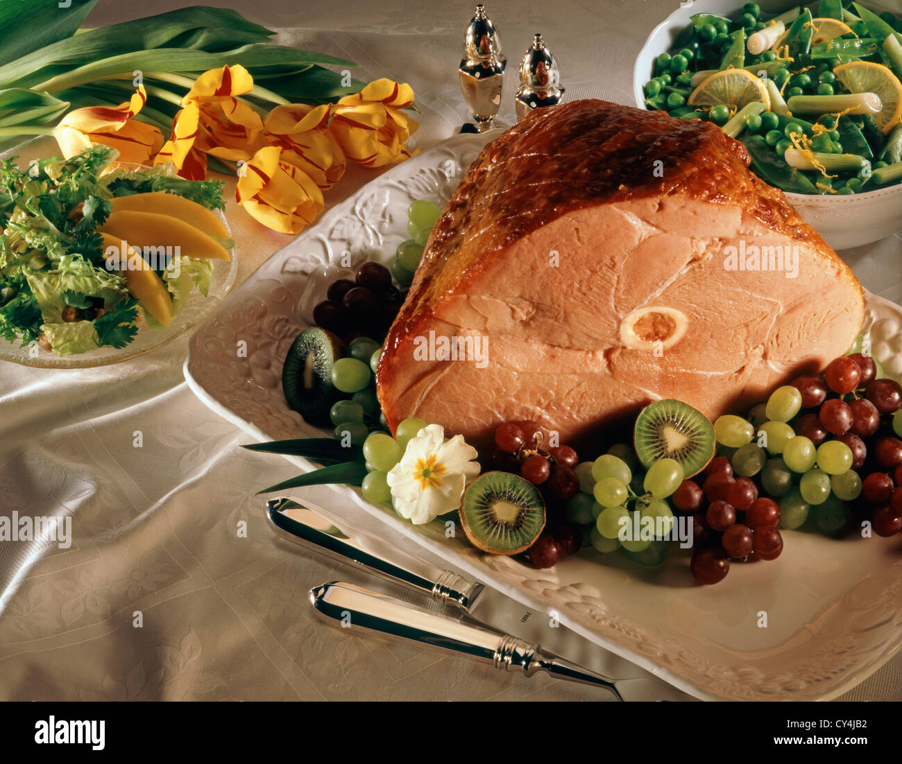 Ham on platter with Fresh tulips salad and vegetables Stock Photo