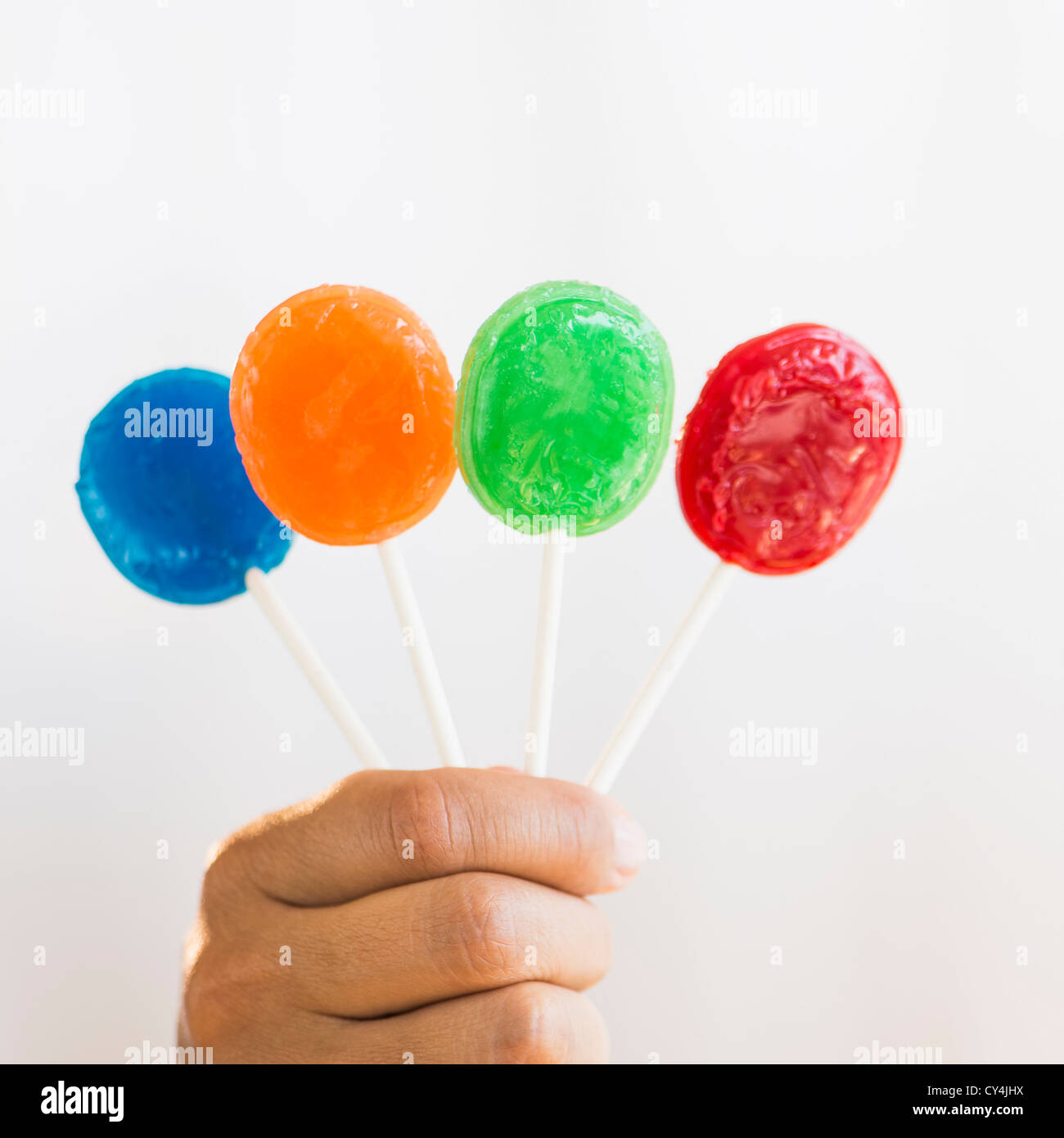 Hand holding colorful lollypops Stock Photo