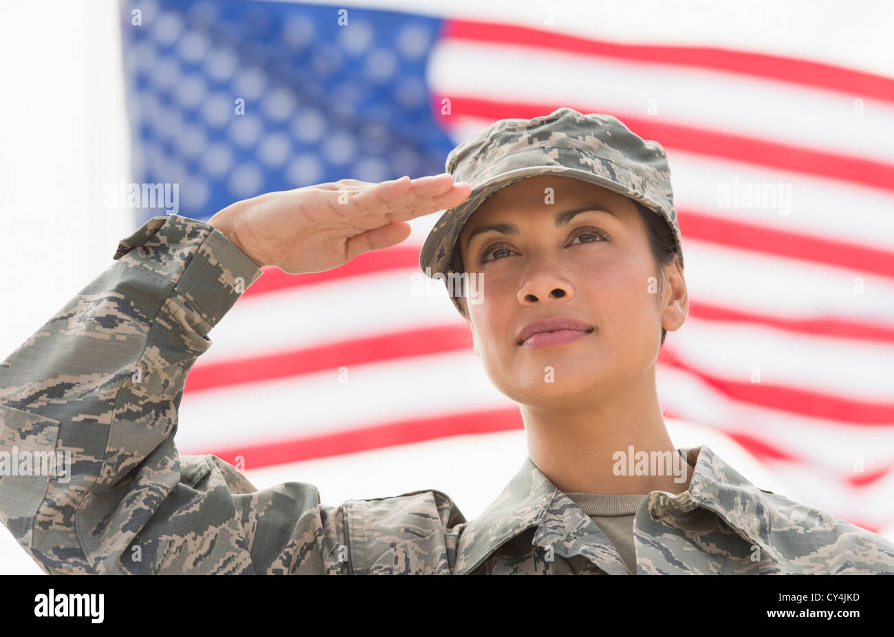 USA, New Jersey, Jersey City, Female army soldier saluting, American flag in background Stock Photo