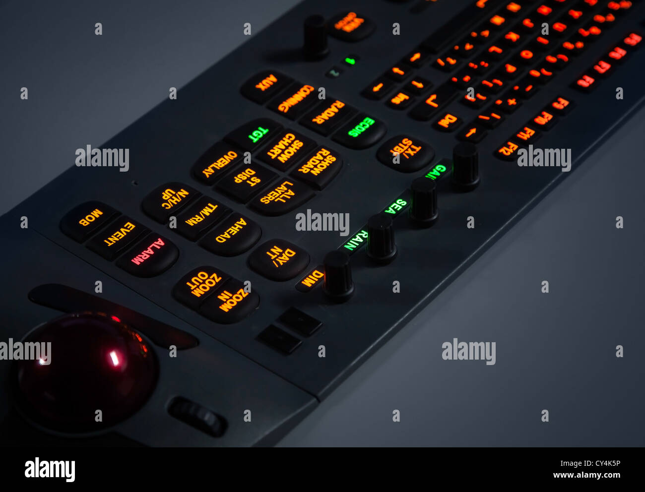 Fragment of colorful illuminated industrial control panel keyboard in the dark. Selective focus Stock Photo