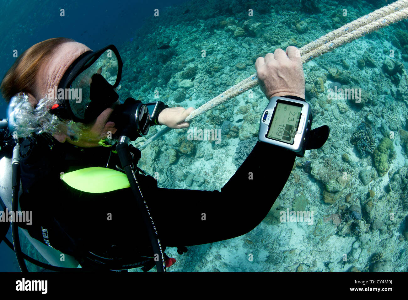 Diver ascends safety line, probably making safety stop after deep dive Stock Photo