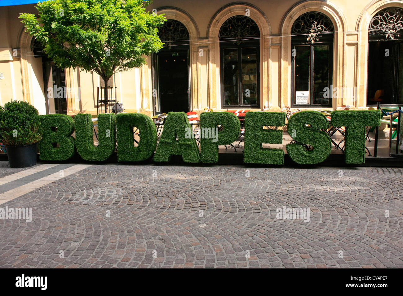 Fake topiary bushes spelling the word Budapest outside a city