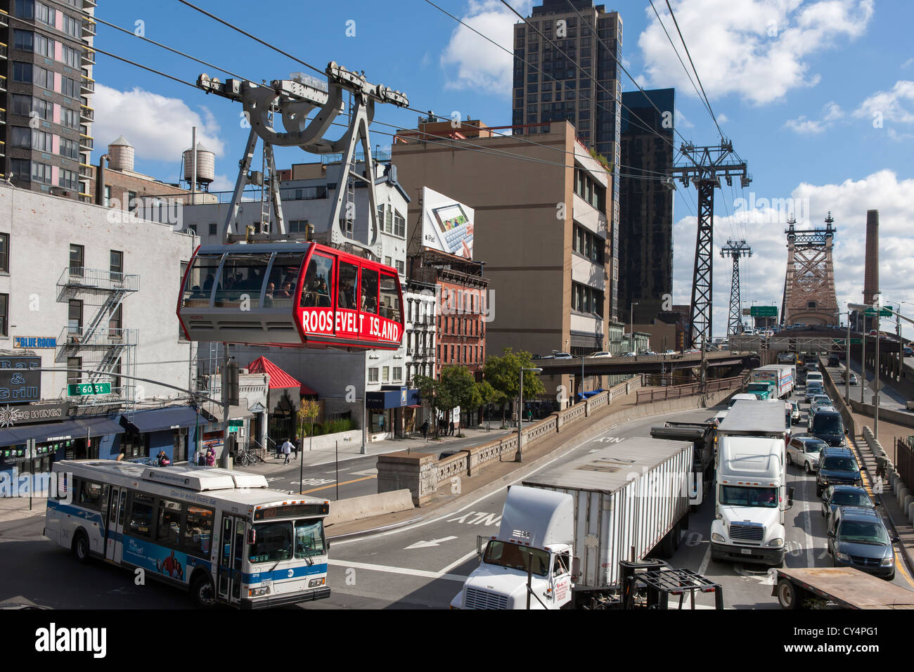 Traffic on the Queensboro bridge is jammed as the Roosevelt Island Tram travels overhead to Roosevelt Island in New York City. Stock Photo
