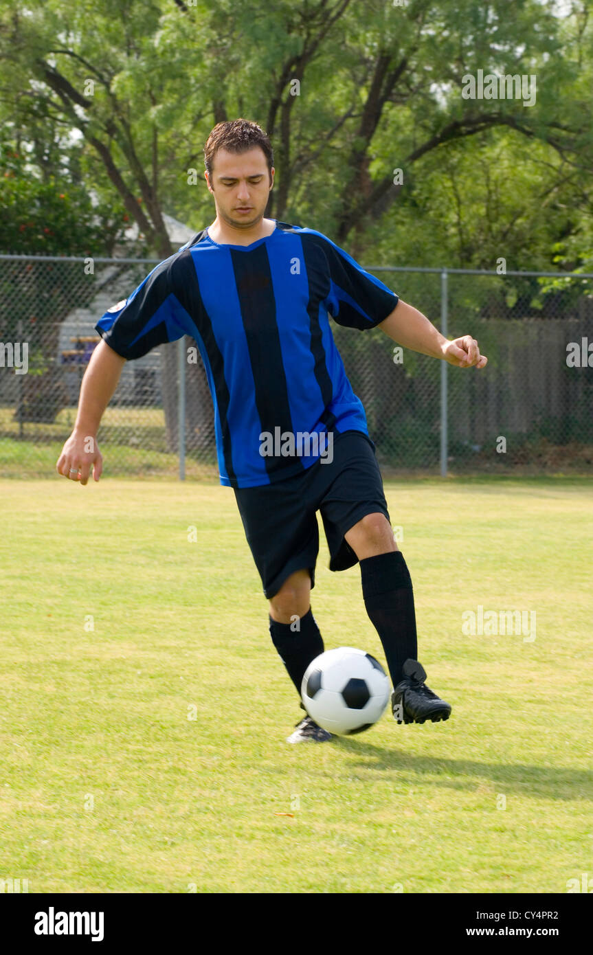 Soccer - Football Player Juggling in blue and black uniform Stock Photo