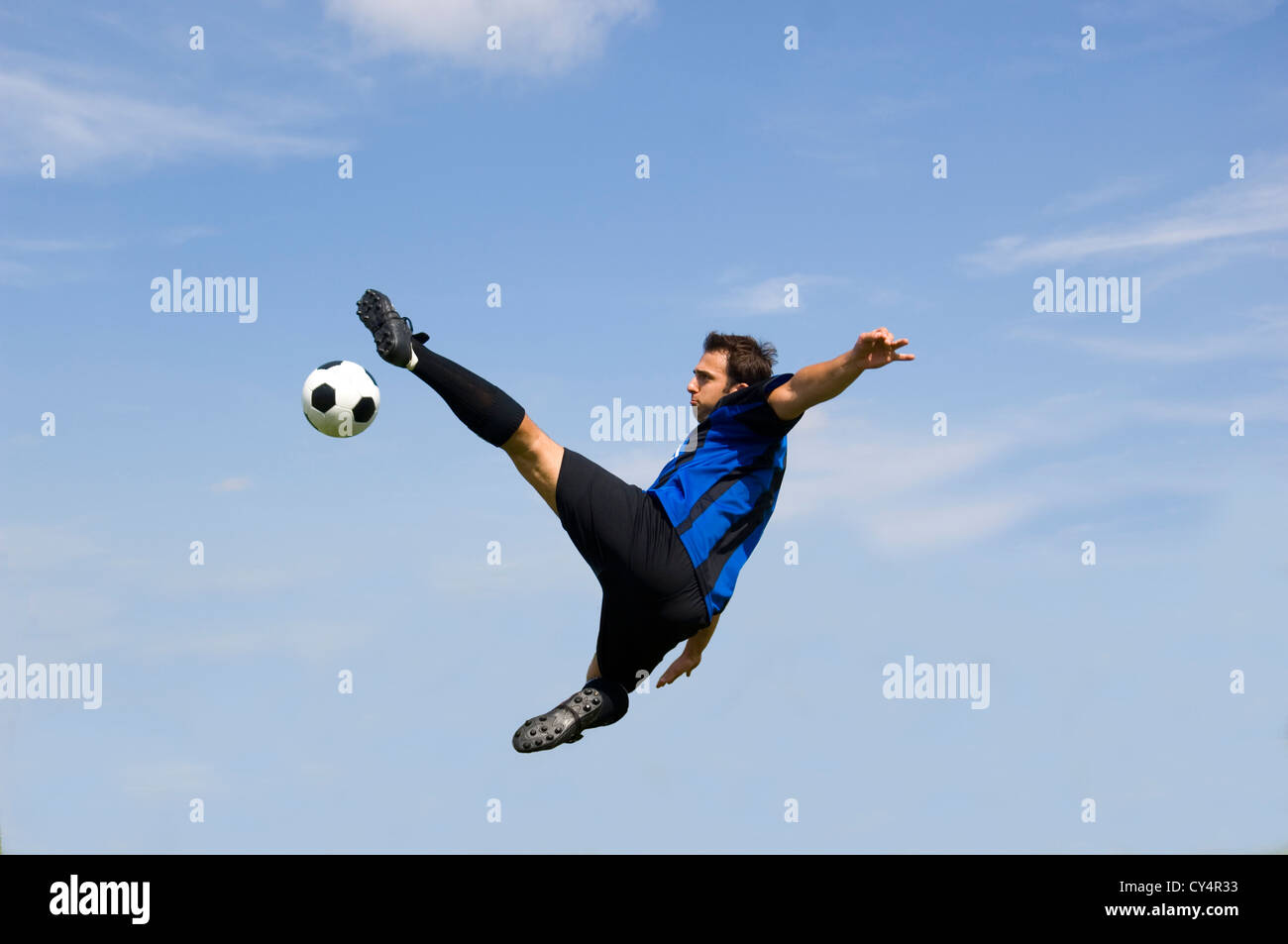 Football - soccer player against blue sky making volley Stock Photo