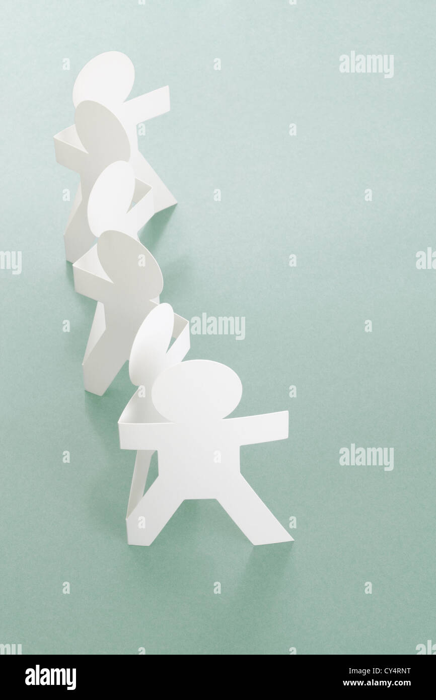 Row of Paper Chain People on Off White Background Stock Photo