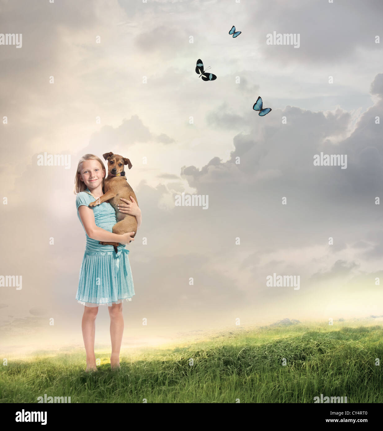 Young Blonde Girl with her Dog on a Magical Mountain Stock Photo