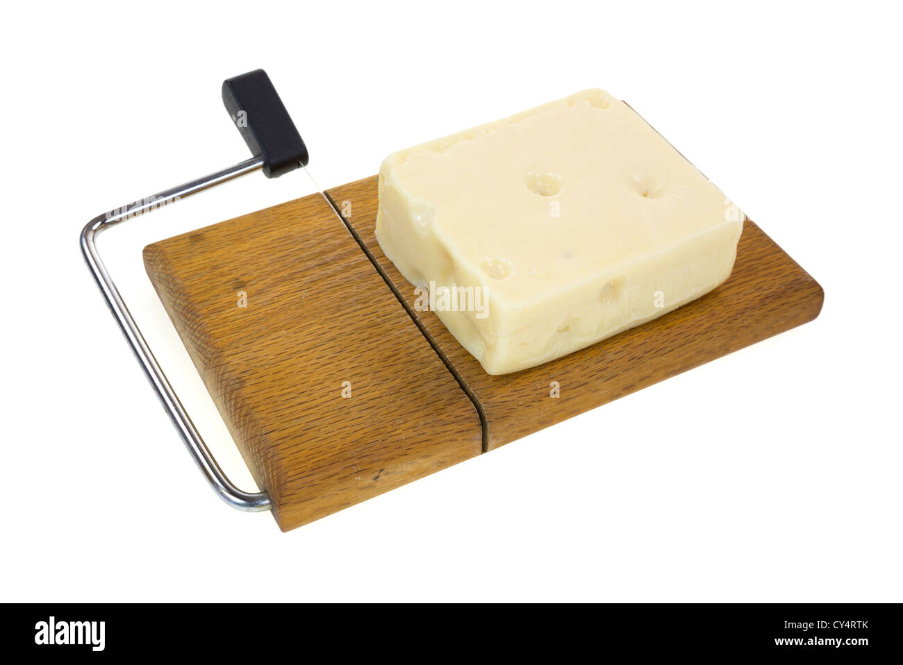 A block of aged Swiss cheese on an old wood cheese cutting board with wire and handle on a white background. Stock Photo