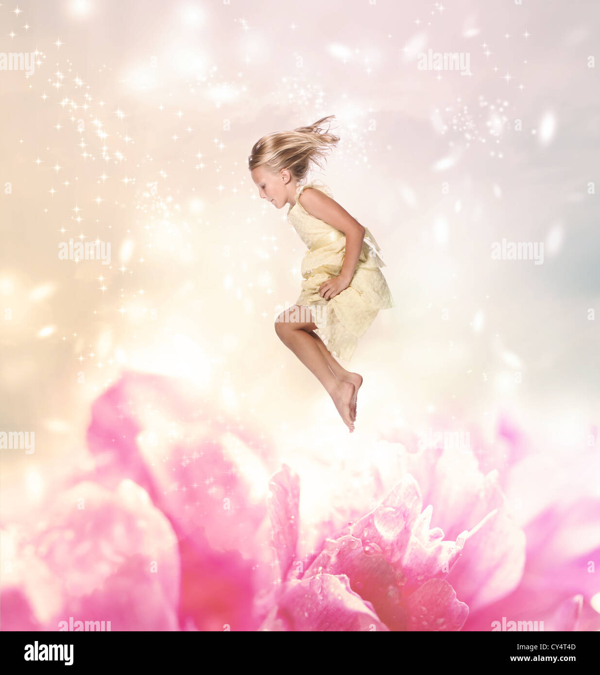 Blond Girl Jumping into a Giant Flower Stock Photo