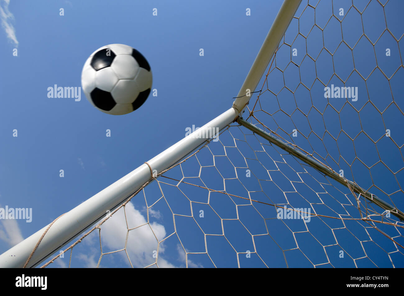 Football - soccer ball in goal against blue sky Stock Photo