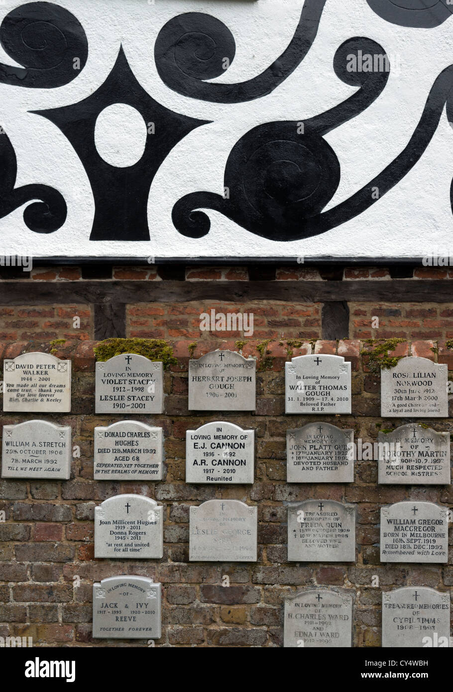 Memorial plaques within Denham village church below part of a painted and decorated gable. Stock Photo
