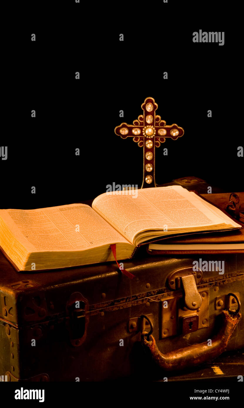 Vintage, antique religious items painted with light. Missionary items including a Bible, journal, suitcase and cross Stock Photo