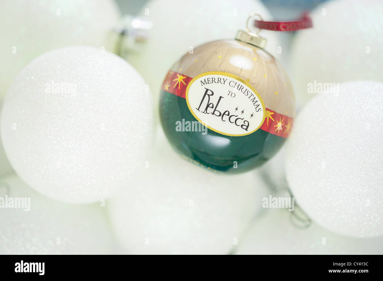 An image of a Christmas Bauble with the name Rebecca printed on it and set amongst other white baubles. Stock Photo
