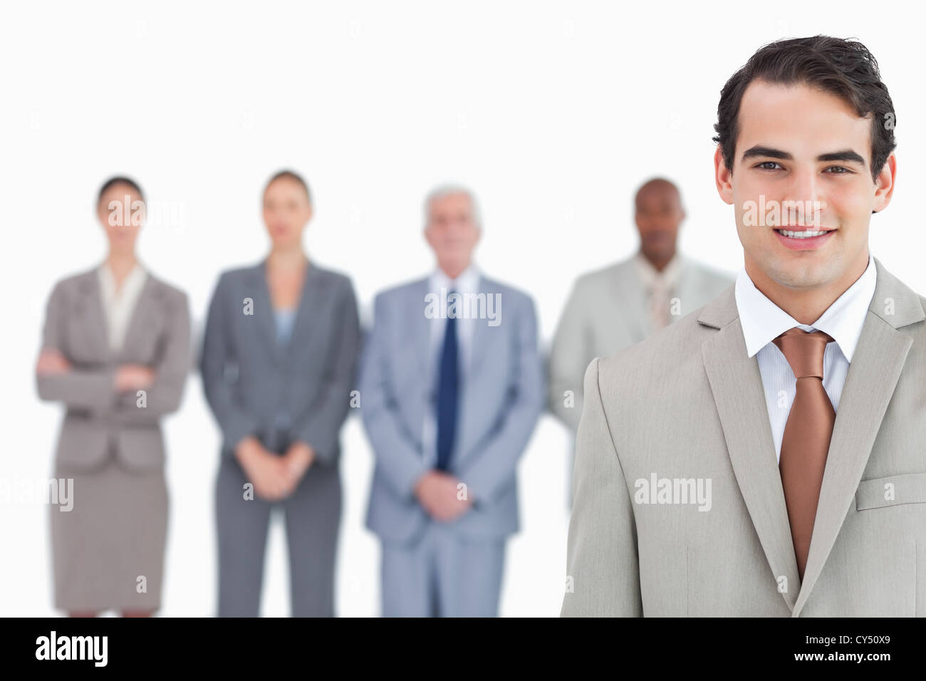 Smiling businessman with his team behind him Stock Photo - Alamy