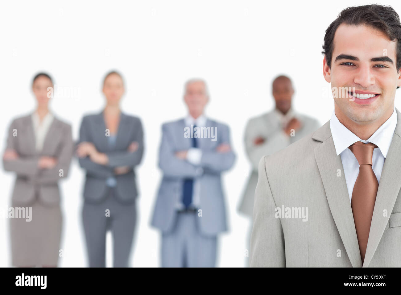 Smiling salesman with his team behind him Stock Photo - Alamy