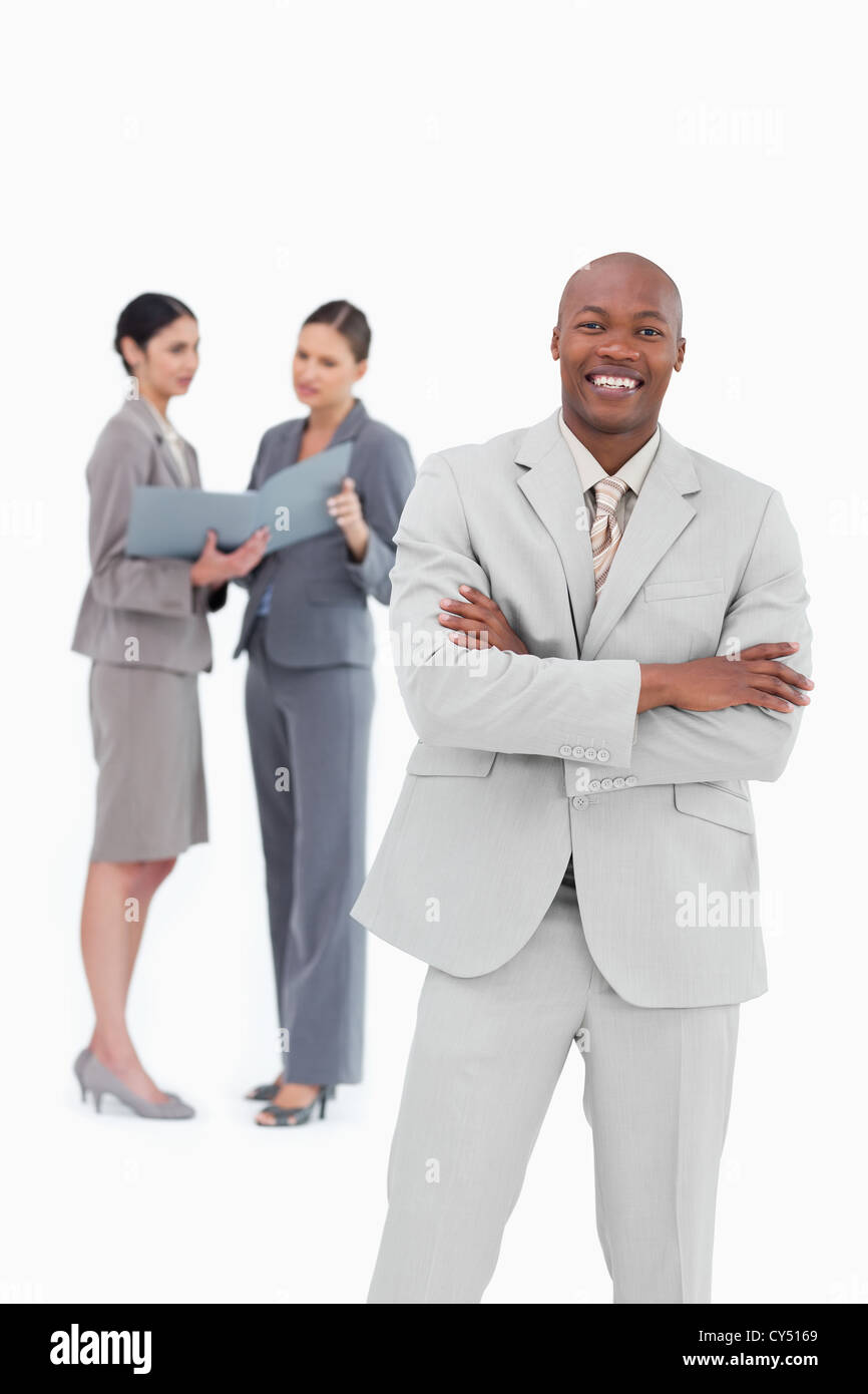 Smiling businessman with co-workers behind him Stock Photo - Alamy