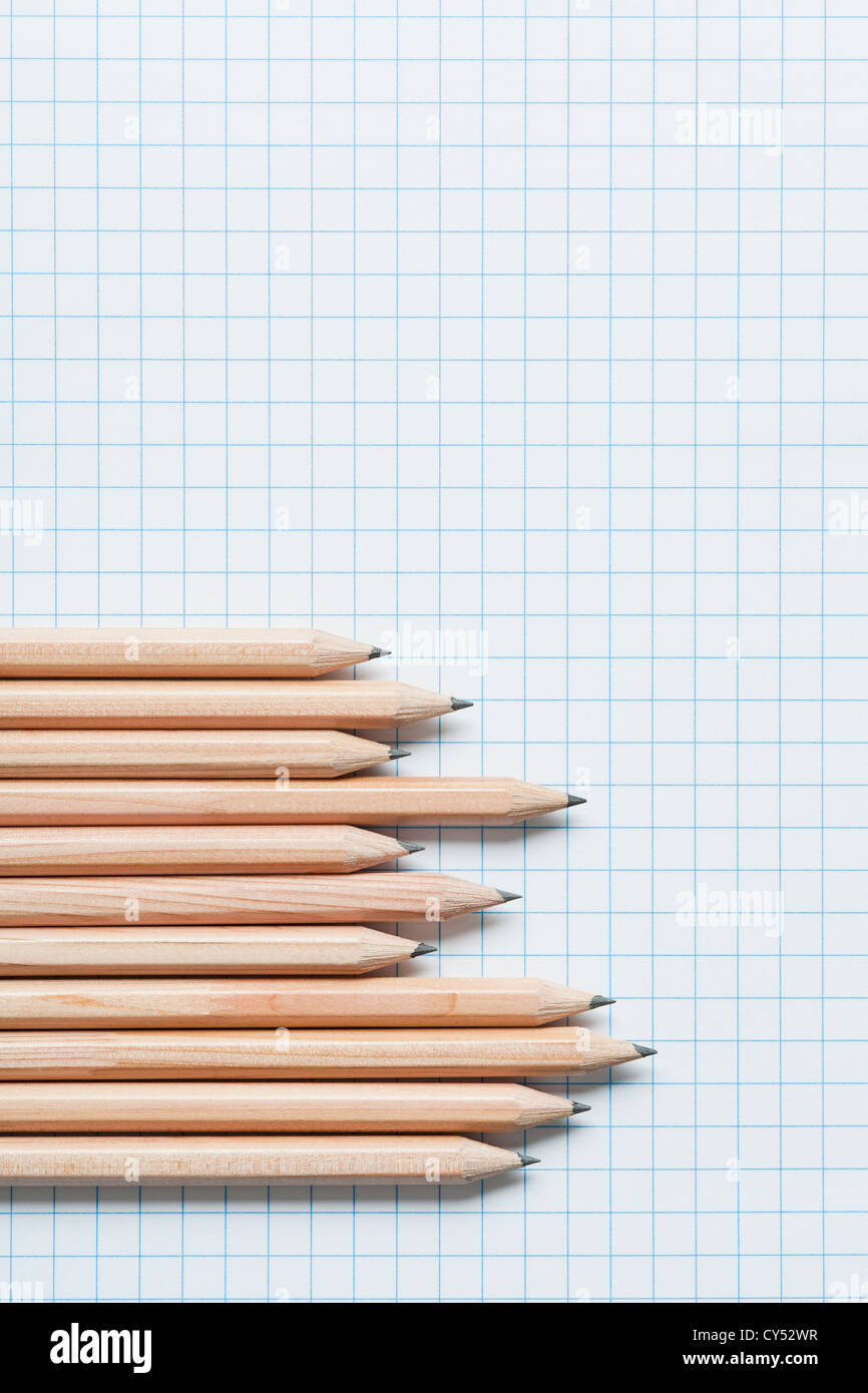Grouping of wooden pencils in graph shape on graph paper Stock Photo