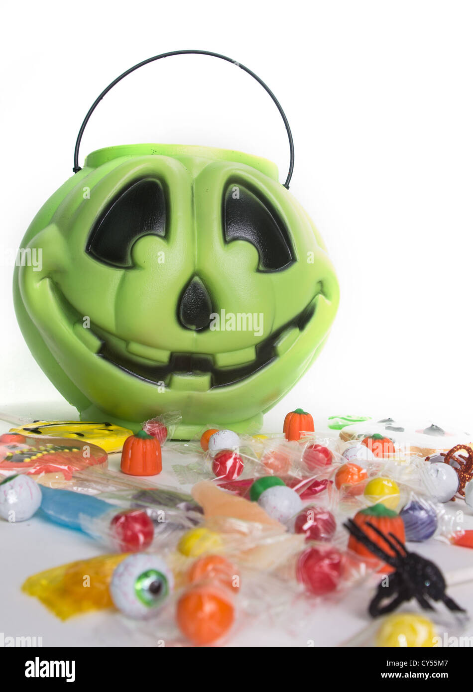 Green pumpkin halloween bucket filled with candy, candy corn, suckers