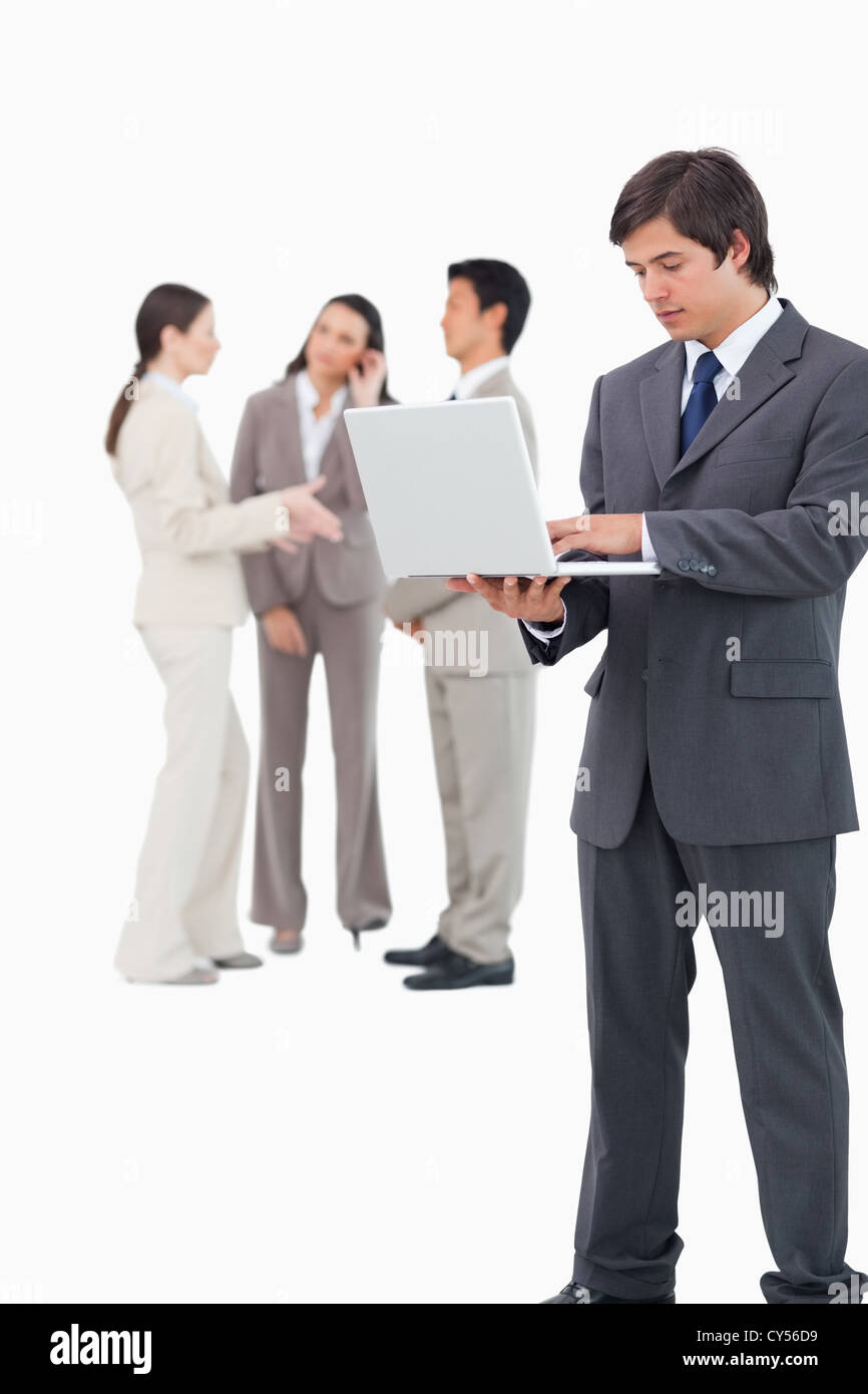 Salesman with laptop and team behind him Stock Photo - Alamy