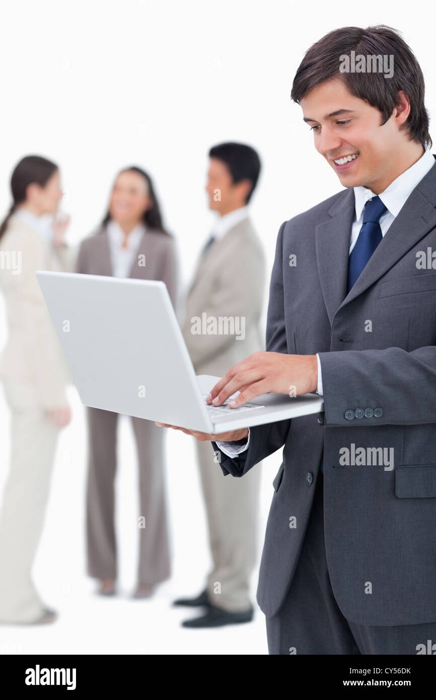 Salesman with notebook and team behind him Stock Photo - Alamy