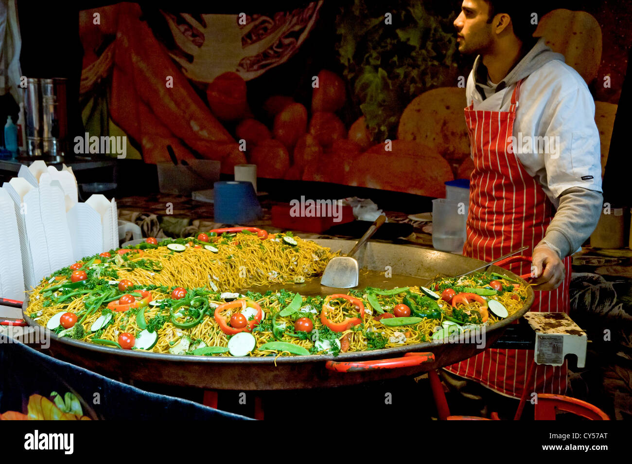 Man cooking food noodles on continental market stall York North Yorkshire England UK United Kingdom GB Great Britain Stock Photo