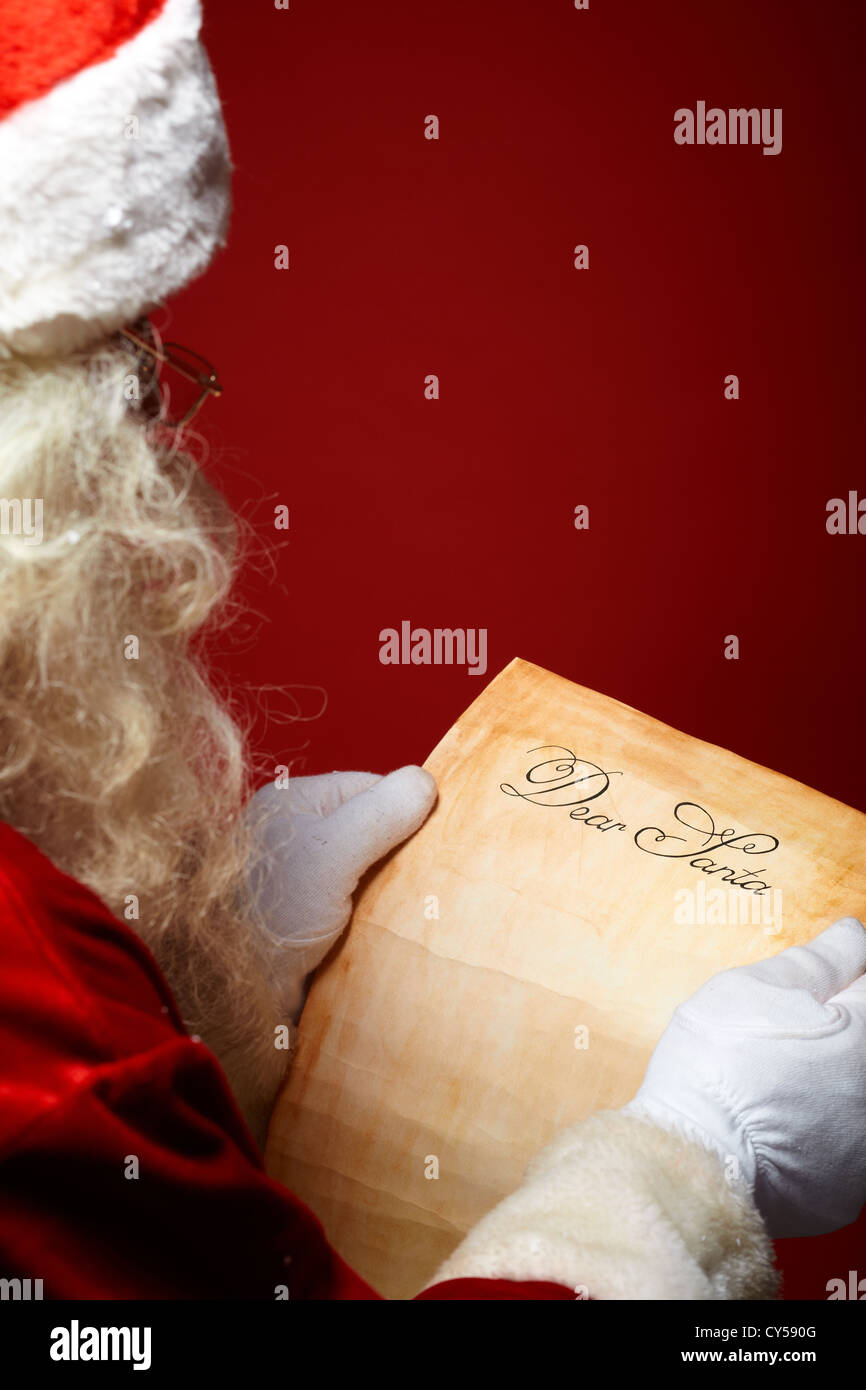 Image of Santa Claus reading Christmas letter in his hands Stock Photo ...