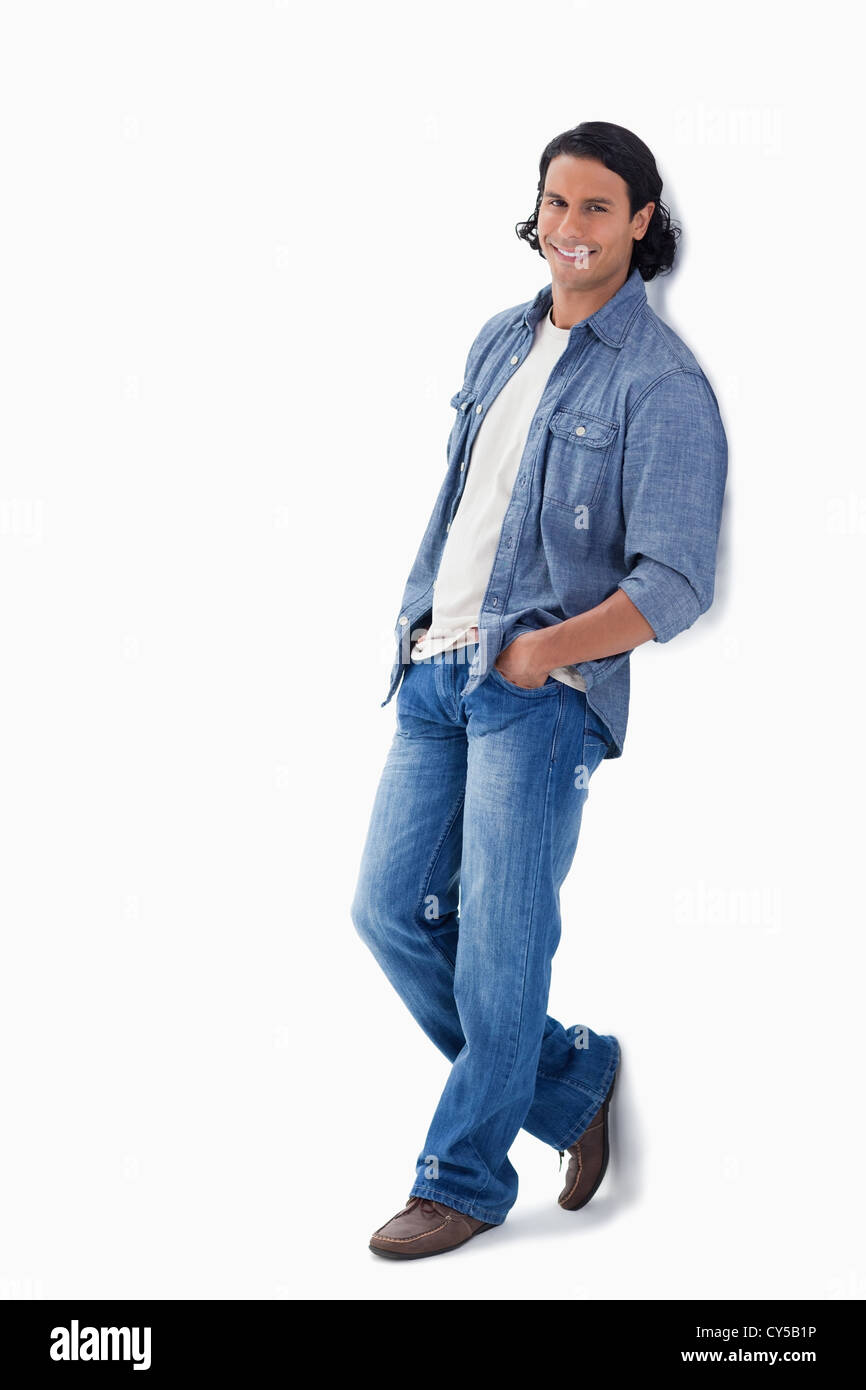 Man smiling while leaning against a wall Stock Photo - Alamy