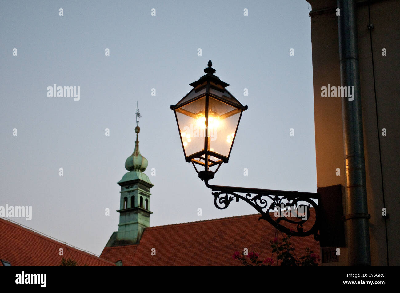 Lit lantern and church spire, Old Town, Zagreb, Croatia Stock Photo