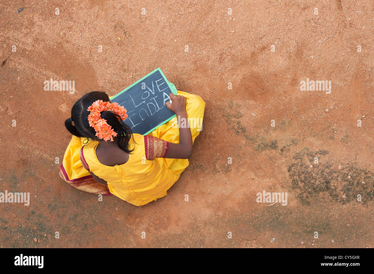 Indian village girl with I LOVE INDIA written on a chalkboard in a rural indian village. Andhra Pradesh, India. Copy space. Stock Photo